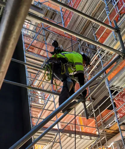 Climber on scaffold with netting