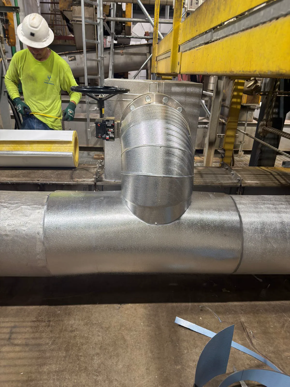 Technician measuring insulated pipe elbow