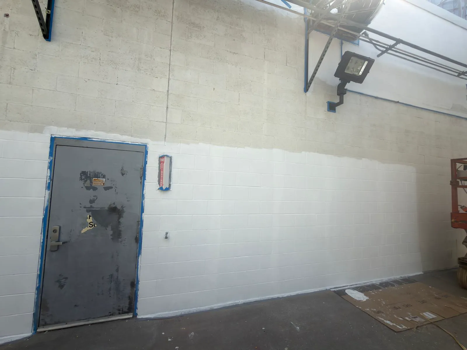 Masonry wall mid-paint with masked door