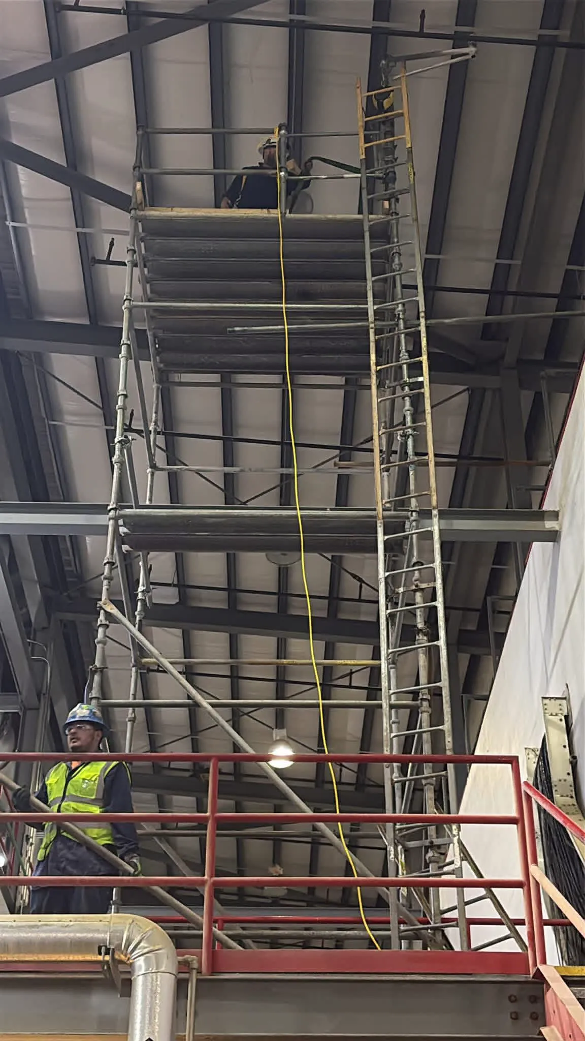 Crew moving equipment on scaffold tower