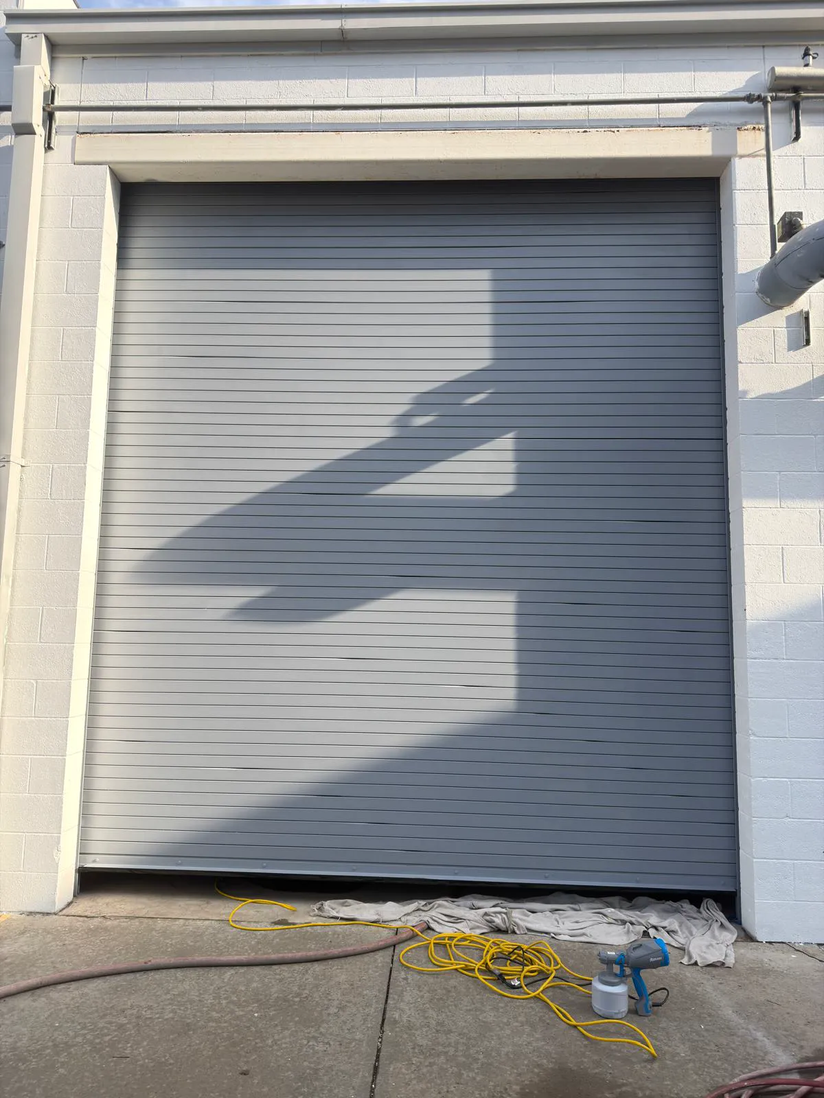 Spray-painted garage door with spray gun